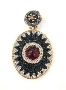 a pendant with a big red stone centered