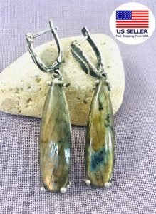a pair labradorite earrings displaying on a stone