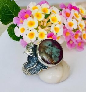 dried flower ring sterling silver upon a stone surrounding by flowers