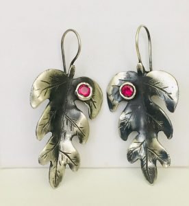 original leaf design ruby stones earrings hanging on the wall