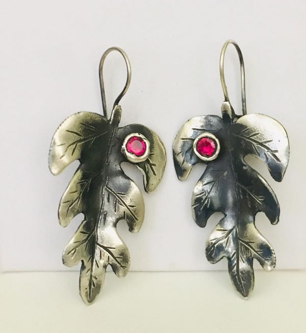 original leaf design ruby stones earrings hanging on the wall