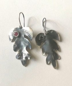 sterling silver earrings with small ruby stones on the wall