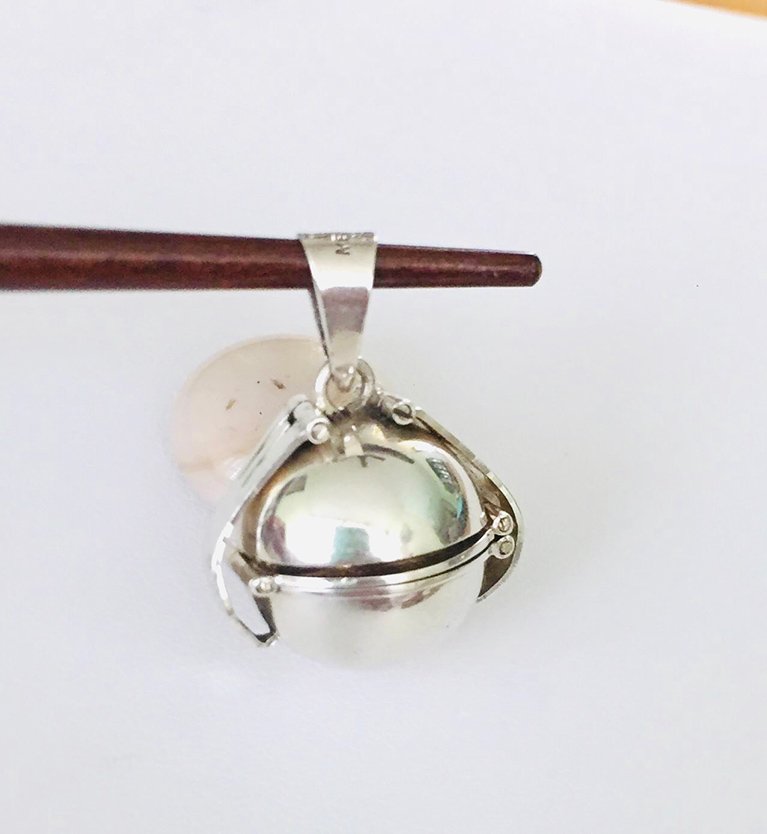 a brown stick holding a pendant
