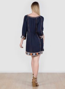 a blond woman wearing embroidered dress