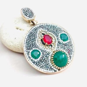 a pendant with emerald and lab stones