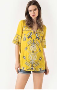 a girl wearing a mustard color short sleeve tunic