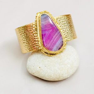 pink color cuff displaying on a cream stone