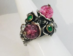 a silver ring with lab emerald and white crystal