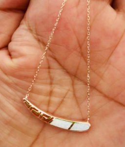 a chain necklace with goldpated on palm of a woman