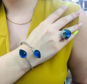 cuff bracelet and ring with blue topaz on a yellow dress wearing woman