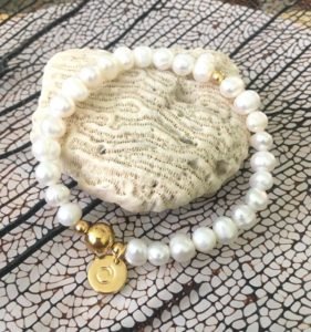 gold spiral bracelet displaying on a stone