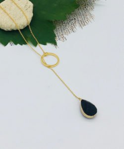 a black onix stone made necklace in white color a green leaf and stone as decorative