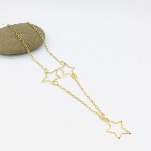 a star necklace stainless steel material is seen in white background on a stone