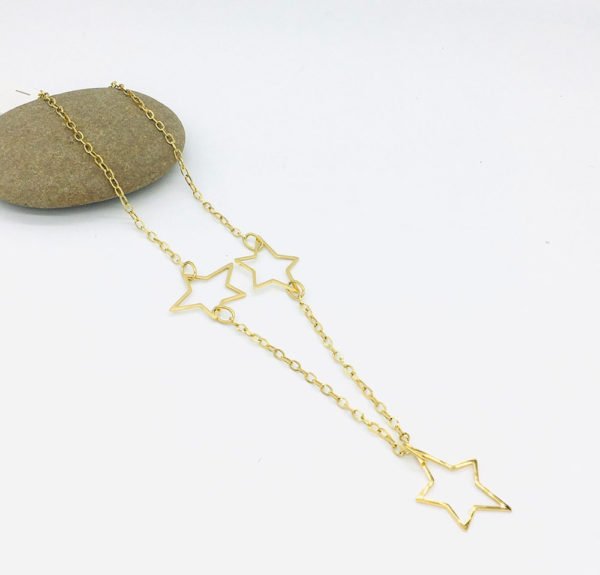 a star necklace stainless steel material is seen in white background on a stone