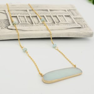 an amazonite necklace displaying on a white bar