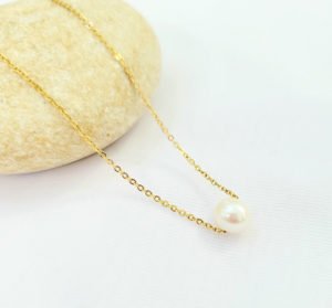 un collar perla dorada