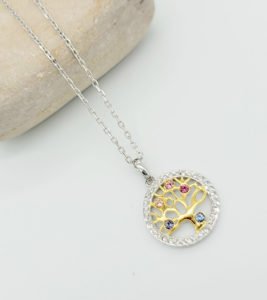 tree of life designed necklace staying under a stone