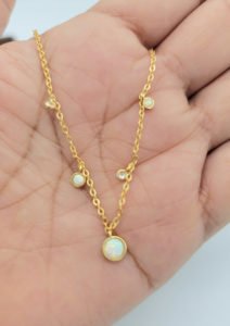 woman holding white opal necklace