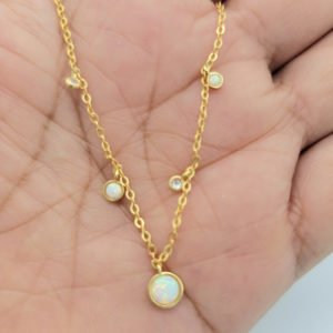 woman holding white opal necklace