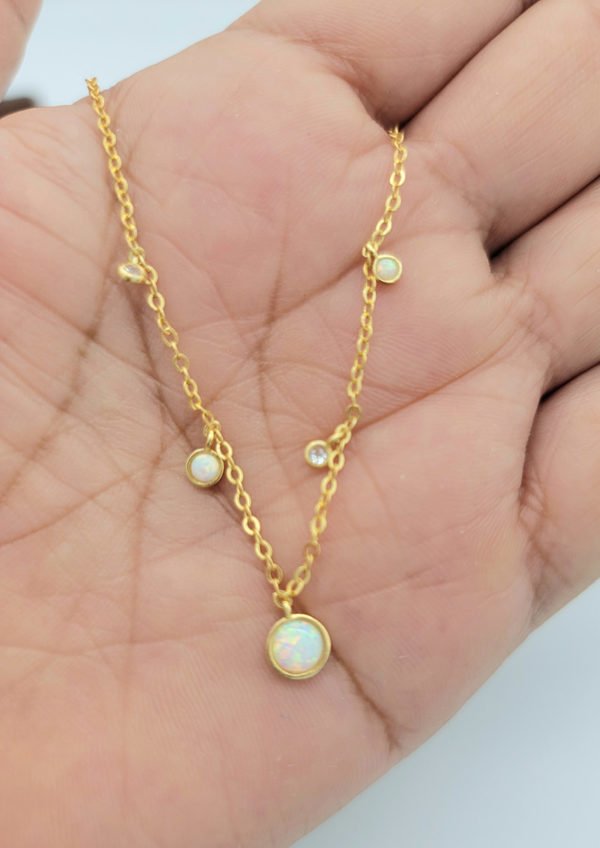 woman holding white opal necklace