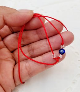 woman holding evil eye bracelet